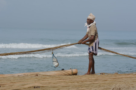 Goa, India - November 4, 2015 - Fishermen catching fishes the traditional way and repairing their huge netsのeditorial素材