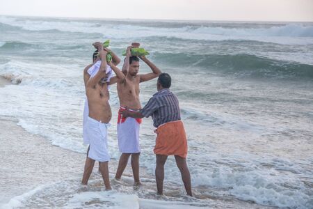 Varkala, India - December 11, 2016 - People and pilgrims praying at holy beach Varkala in Kerala, South India and taking a bath in the holy waterのeditorial素材