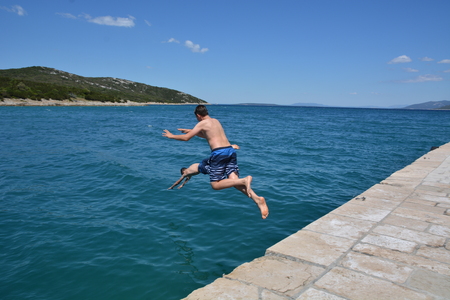 Cres, Croatia - June 18, 2017 - Boys jumping in ocean near Osor on island Cresのeditorial素材