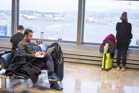 Munich, Germany - July 8, 2018 - Passengers waiting at airport in front of arrival departure board in Munichのeditorial素材