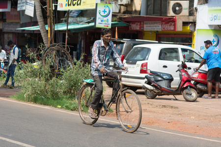 Goa, India - July 8, 2018 - Cyclist in typical traffic situation on indian street in Canacona - Goaのeditorial素材
