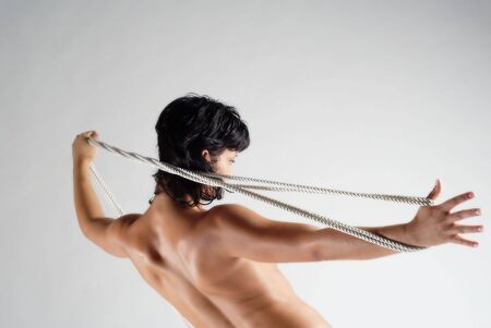 Naked beautiful woman holding ropeの写真素材