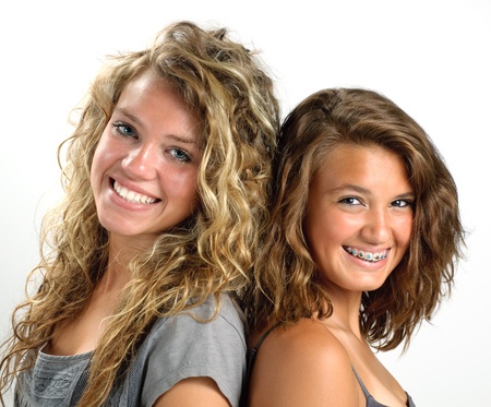 Two sisters back to back smilingの写真素材