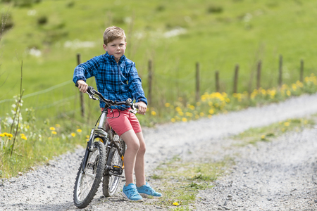 Boy resting on a bikeの写真素材