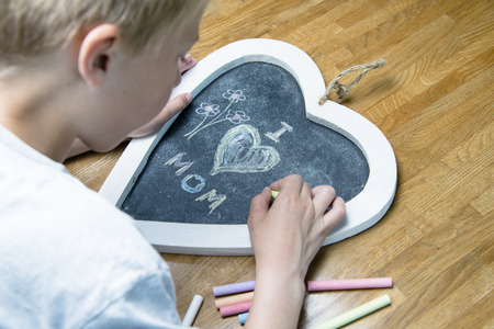 Boy writing I love mom for motherの写真素材
