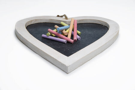 Isolated heart shaped blackboard with colored chalkの写真素材