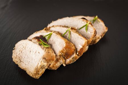 slices of roast ham on a stone plateの写真素材