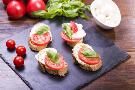 small sandwich with tomato and mozzarella, decorated with basil leafの写真素材