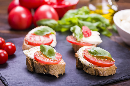 small sandwich with tomato and mozzarella, decorated with basil leafの写真素材
