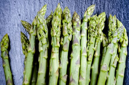Blanched green asparagus on brown plateの写真素材