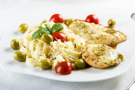 Chicken fillet in tomato sauce with olives and grated mozzarellaの写真素材