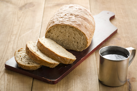loaf of bread on a board and coffeeの写真素材