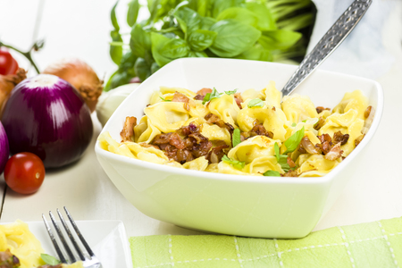 Tortellini dumplings with ham and basilの写真素材