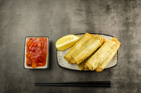 Spring rolls with vegetables, chopsticks and sweet and sour sauceの写真素材
