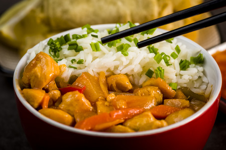 Chicken in sweet and sour sauce with rice and spring rollsの写真素材