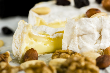 Camembert with nuts, fruit and honey on a wooden tableの写真素材