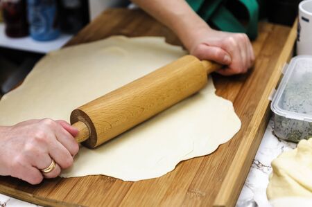 rolling the dough on the tableの写真素材