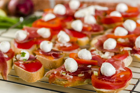bruschetta with tomatoes, mozzarella, Parma ham and basil - seasoned with oreganoの写真素材