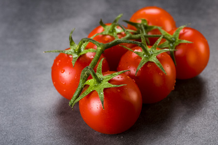 twig with tomatoes on a stone foundation - red on a dark backgroundの写真素材