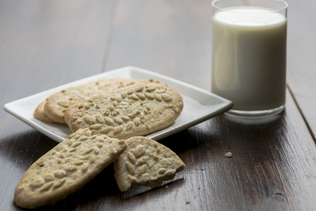 cereal cookies and a glass of milk on a wooden tableの写真素材