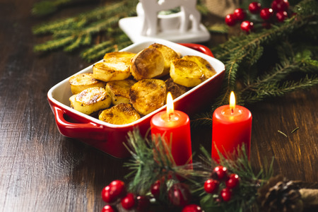 Baked vegetables on a wooden table - an addition to the Christmas fishの写真素材