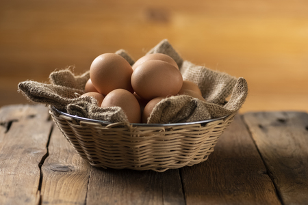 Eggs in a basket on a wooden table in an agritourism farmの写真素材