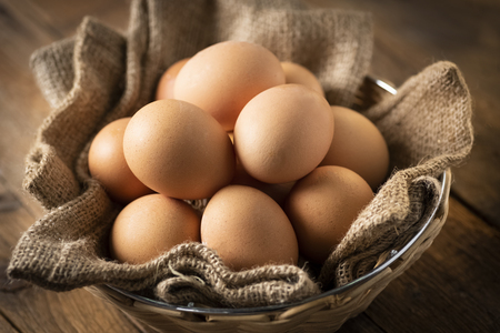 Eggs in a basket on a wooden table in an agritourism farmの写真素材