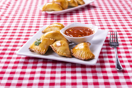 Empanada - a dish of South American cuisine - baked dumplings stuffed with meat and vegetableの写真素材
