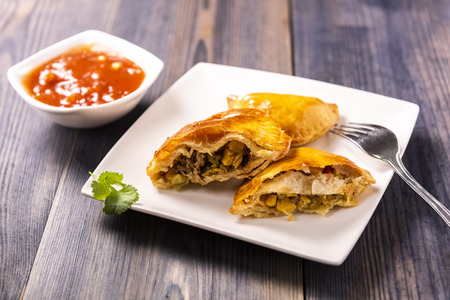 Empanada - a dish of South American cuisine - baked dumplings stuffed with meat and vegetableの写真素材