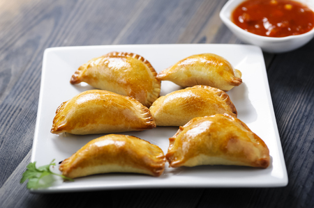Empanada - a dish of South American cuisine - baked dumplings stuffed with meat and vegetableの写真素材
