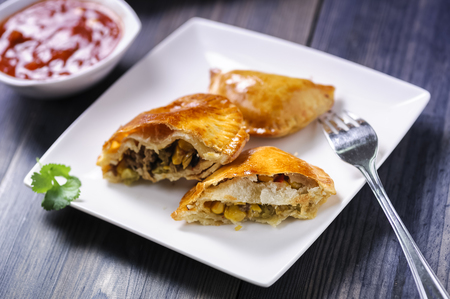 Empanada - a dish of South American cuisine - baked dumplings stuffed with meat and vegetableの写真素材