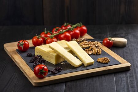 cheese board - cheddar cheese with nuts, cranberries and cherry tomatoesの写真素材
