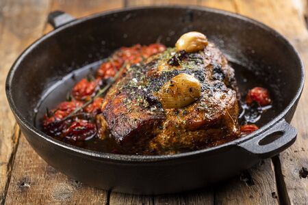 homemade ham baked in herbs with cherry tomatoesの写真素材