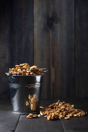 shelled walnuts in a metal bucket on a wooden tableの写真素材