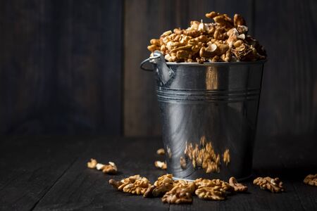 shelled walnuts in a metal bucket on a wooden tableの写真素材