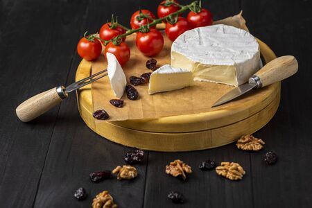 camembert cheese with nuts, cranberries and cherry tomatoesの写真素材