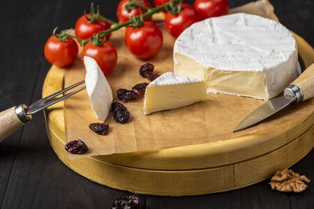 camembert cheese with nuts, cranberries and cherry tomatoesの写真素材
