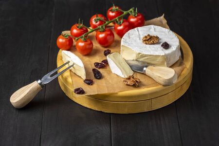 camembert cheese with nuts, cranberries and cherry tomatoesの写真素材