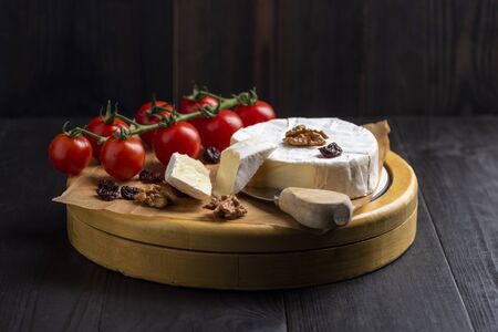 camembert cheese with nuts, cranberries and cherry tomatoesの写真素材