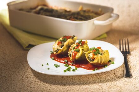shell-shaped pasta stuffed with spinach and cheese baked in tomato sauceの写真素材