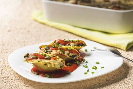 shell-shaped pasta stuffed with spinach and cheese baked in tomato sauceの写真素材