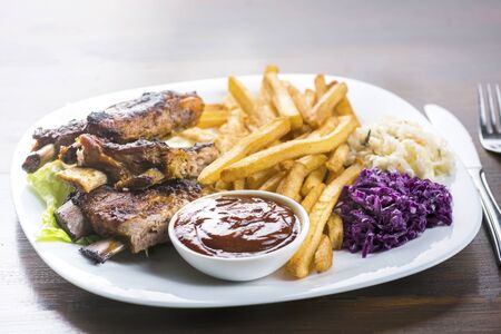 baked ribs with French fries and cabbage saladの写真素材