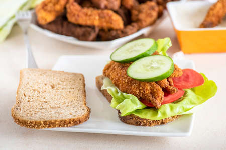 sandwich with homemade chicken strips coated in corn and garlic sauceの写真素材