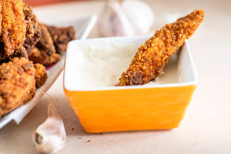 sandwich with homemade chicken strips coated in corn and garlic sauceの写真素材