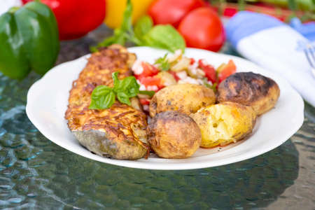 baked zucchini served with baked potatoesの写真素材