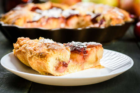 homemade apple and plum cake on wooden tableの写真素材