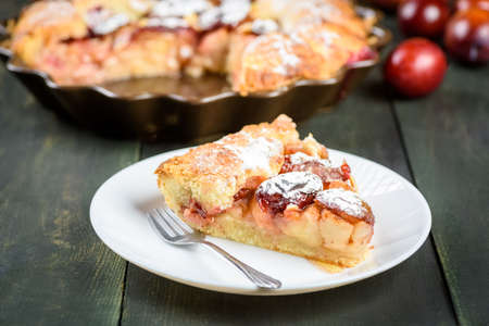 homemade apple and plum cake on wooden tableの写真素材