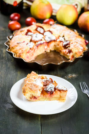 homemade apple and plum cake on wooden tableの写真素材