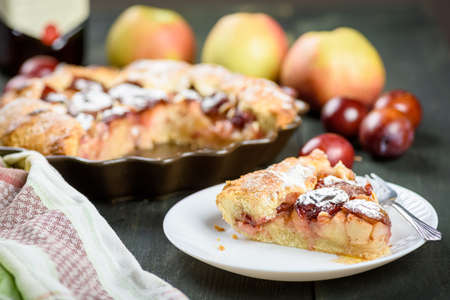 homemade apple and plum cake on wooden tableの写真素材