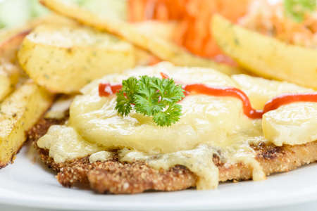 Hawaiian cutlet with baked potatoes and a bouquet of saladsの写真素材